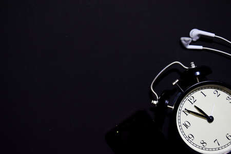 black vintage alarm clock on the black backgroundの写真素材