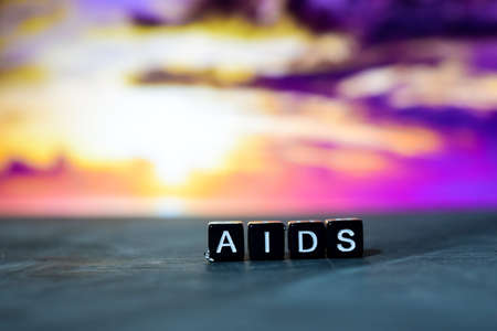 AIDS on wooden blocks. Cross processed image with bokeh background