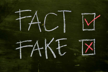 Fact or Fake written with color chalk concept on the blackboardの写真素材