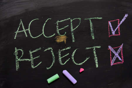 Accept or Reject written with color chalk concept on the blackboardの写真素材