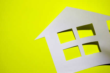Concept of house in paper on yellow background. Horizontal composition. Top view.の写真素材