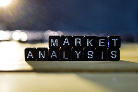 MARKET ANALYSIS concept wooden blocks on the table. With personal development and motivation concept on blurred or black backgroundの写真素材