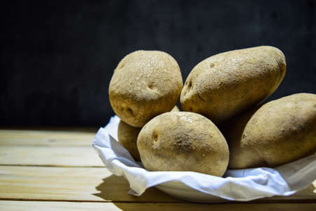 Close-up Fresh potatoes lying on wooden tableの写真素材