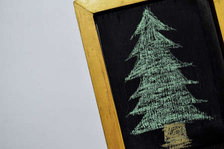 Christmas - New Year holiday background - chalkboard in wooden frame on white background with Hand Drawn Doodle Christmas Tree Chalkの写真素材