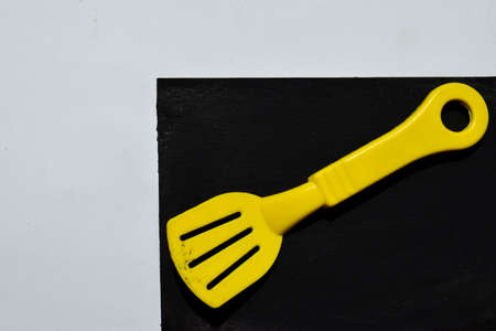 Yellow plastic fork isolated on blackboard. In white backgroundの写真素材