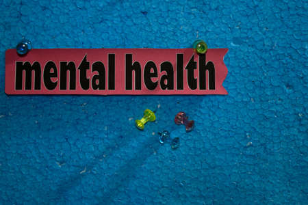 Mental Health text on the paper is attached to the foam with push pins, Health care concept as a schedule remindersの写真素材