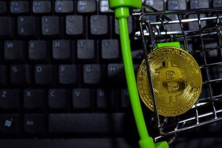 Bitcoin gold in Shopping cart on keyboard laptop background. Trade and business concept