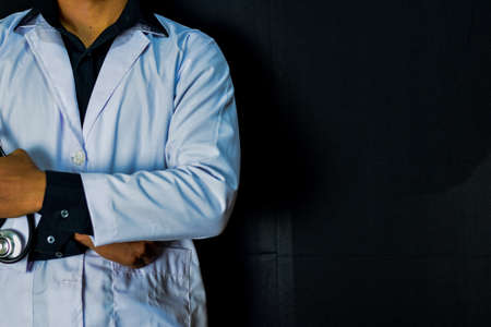 Physician or doctor holding stethoscope. Listening story patient concept. Isolated on black backgroundの写真素材