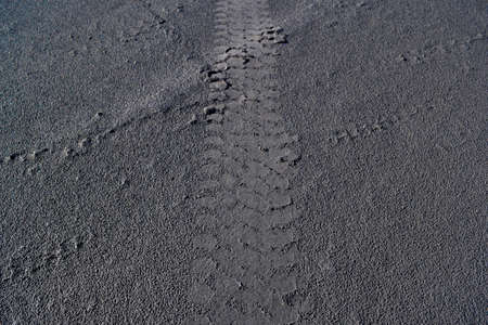 The car tracks on the ground. Tyre track on dirt sand or mud