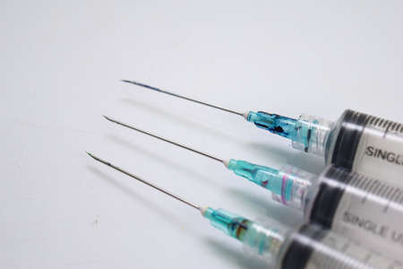 Close up of a syringe selective focus on needle, isolated on white background