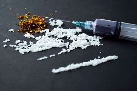 Cocaine and Selective focus on syringe ready for uses on dark table.の写真素材