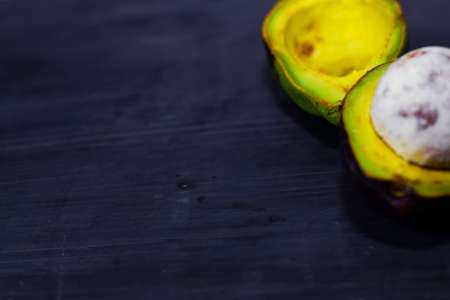 Close up fresh organic avocado halves on old black table background. Healthy food concept