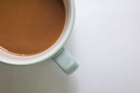 Close up hot cappuccino coffee in a blue cup isolated on a white background