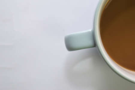 Close up hot cappuccino coffee in a blue cup isolated on a white backgroundの写真素材