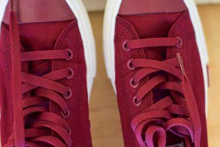 Close up a red sneakers isolated on wooden background. Put your text designの写真素材