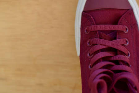 Close up a red sneakers isolated on wooden background. Put your text designの写真素材