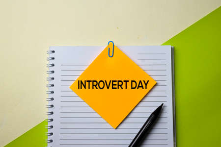 Introvert Day text on top view office desk table of Business workplace and business objects.