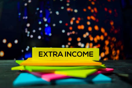 Extra Income on the sticky notes with bokeh backgroundの写真素材