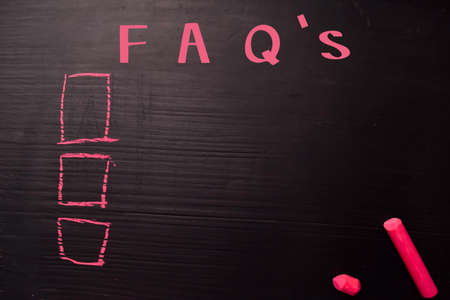 FAQ's written with color chalk. Supported by an additional services. Blackboard concept