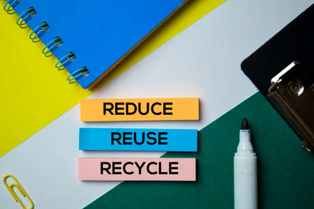 Reduce. Reuse. Recycle text on sticky notes with office desk conceptの写真素材