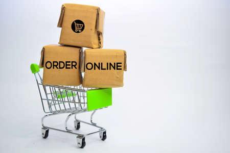 Order Online Text in small boxes and shopping cart. Concepts about online shopping. Isolated on white backgroundの写真素材
