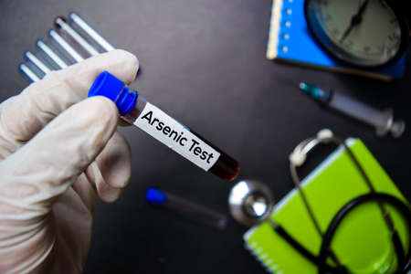 Arsenic Test text with blood sample. Top view isolated on black background. Healthcare/Medical conceptの写真素材