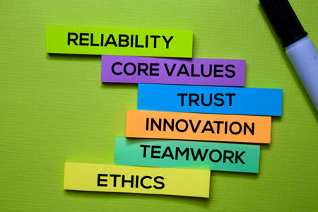 Reliability, Core Values, trust, Innovation, Teamwork, Ethics text on sticky notes isolated on green...