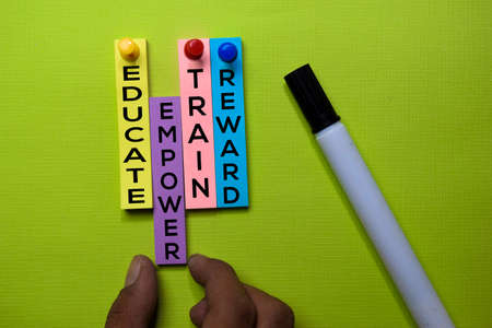 Educate, Train, Empower, Reward text on sticky notes isolated on green desk. Mechanism Strategy Conceptの写真素材