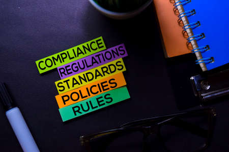 Compliance, Regulations, Strandards, Policies, Rules text on sticky notes isolated on Black desk. Mechanism Strategy Conceptの写真素材