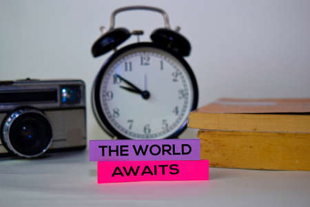 The World Awaits text on sticky notes isolated on desk backgroundの写真素材