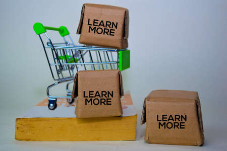 Learn More Text in small boxes and shopping cart. Concepts about online shopping. Isolated on white...