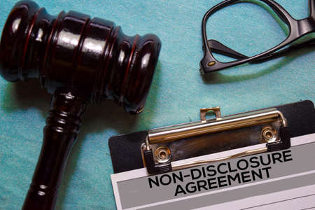 Non-Disclosure Agreement text on Document and gavel isolated on office desk.の写真素材