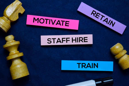 Train, Staff Hire, Rerain and Motivate on sticky Notes isolated on office deskの写真素材