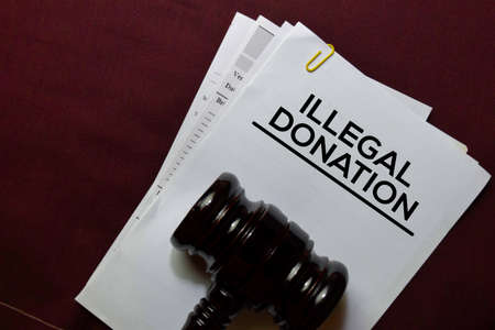 Illegal Donations document form and Black Judges gavel on office desk. Law concept