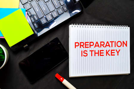 Preparation Is The Key text on a book at office desk. Isolated on black bakgroundの写真素材