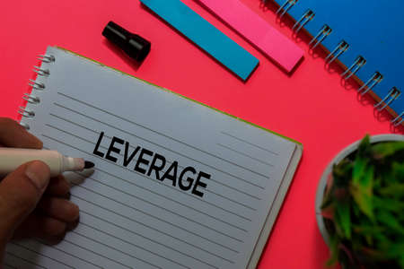 Leverage write on book. Isolated on pink table backgroundの写真素材
