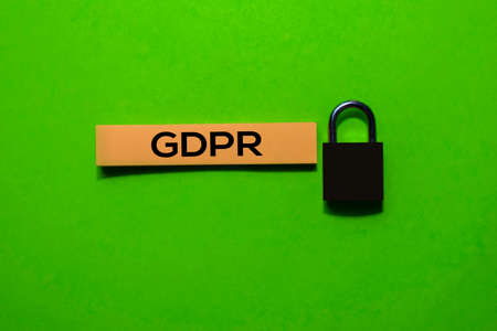 GDPR write on sticky notes and padlock. Isolated on green table background