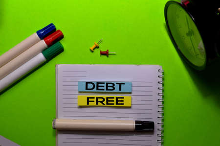 Debt Free write on sticky notes. Isolated on green table backgroundの写真素材