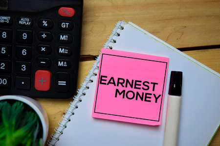 Earnest Money write on sticky note with wooden table backgroundの写真素材