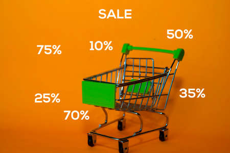 Trolley or shopping cart with Sale Discount write on Yellow Background. Shopping Conceptの写真素材