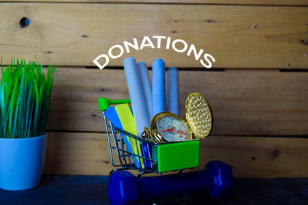 Stationery or Equipment for school in Trolley on wooden table. Donations Concept