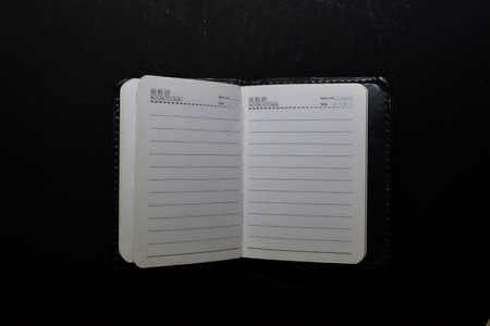 Close up white notebook isolated on black backgroundの写真素材