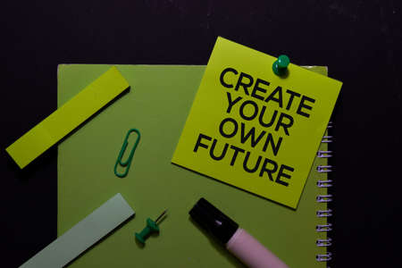 Create Your Own Future write on Sticky Notes. Top view isolated on black background.の写真素材