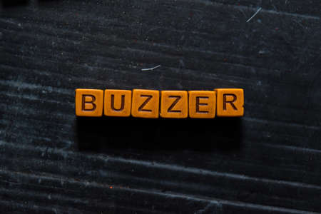 Buzzer on wooden cubes. On table background