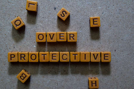 Over Protective on wooden cubes. On table backgroundの写真素材