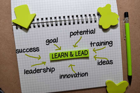 Learn and Lead on sticky note with keywords isolated on wooden background. Chart or mechanism concept.の写真素材