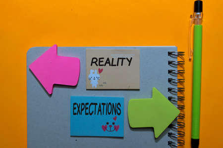 Reality or Expectations write on sticky notes isolated on Office Deskの写真素材