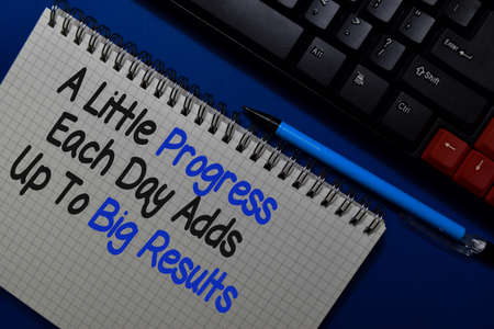 A Little Progress Each Day Adds Up to Big Results write on a book isolated on Office Deskの写真素材