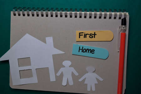 First Home write on stick note isolated on Office Deskの写真素材