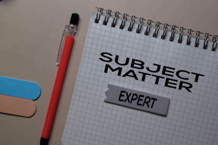 Subject Matter Expert write on a book isolated on Office Desk